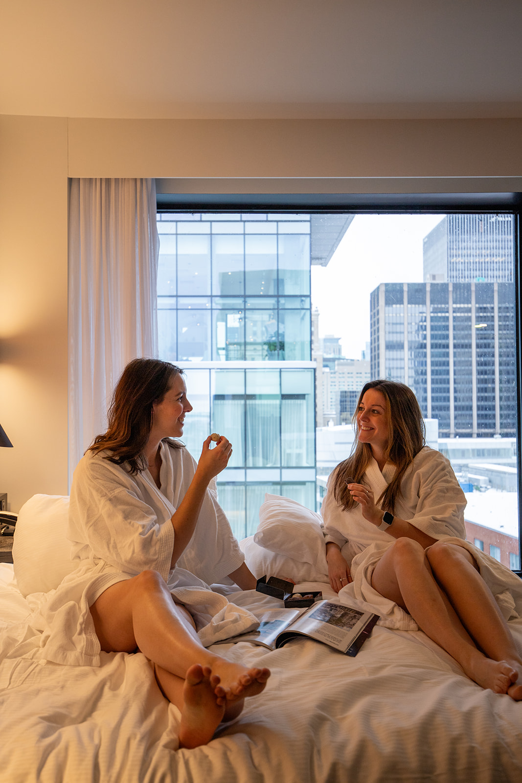 Deux femmes qui mangent du chocolat sur le lit à l'hôtel Monville